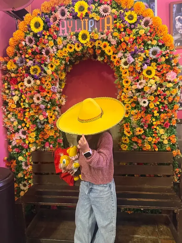 Clienta celebrando frente al arco de flores